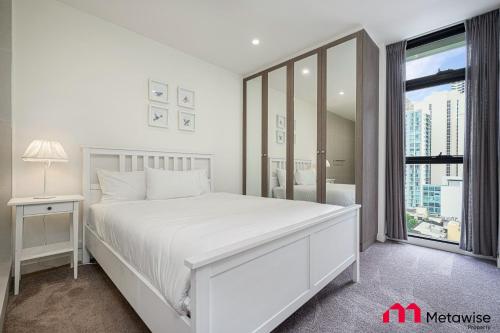 悉尼MetaWise Sydney CBD Haymarket Luxe 2Bed Penthouse Bella的白色的卧室设有一张白色大床和一个窗户。