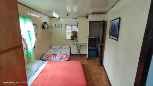 碧瑶Kochimoto Homestay的小房间设有两张床和一台冰箱