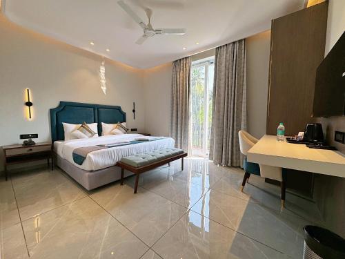 GoaSkon Baga Bliss Hotel by Orion Hotels的一间卧室配有一张床、一张桌子和一张桌子