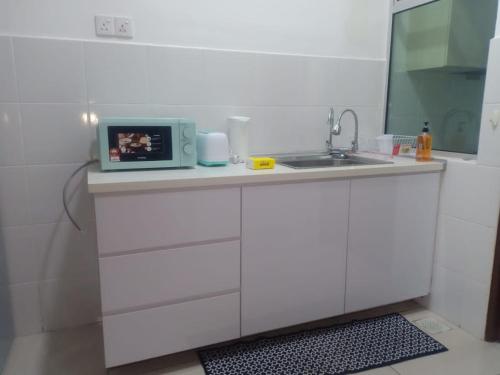 Bandar PenawarHomestay Desaru Utama @Escadia的白色的厨房配有水槽和微波炉