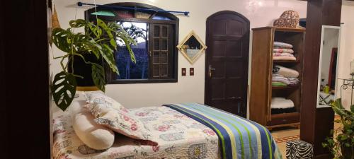 卡波布里奥Red Rose的一间卧室配有一张床和盆栽植物