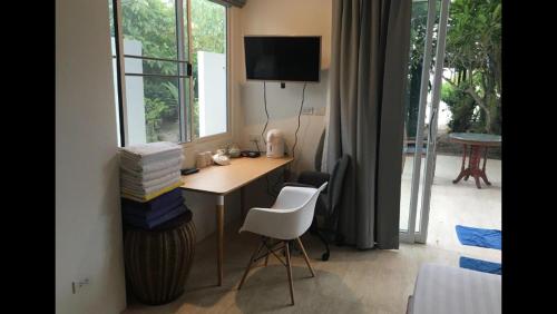 苏梅岛Bangpo Village Tiny Country Beach House的客房设有带椅子的书桌和窗户。