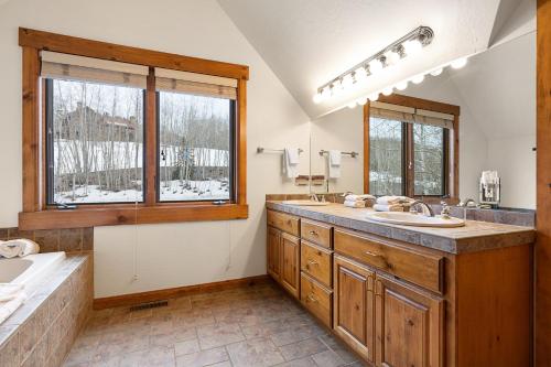 特柳赖德Russell Home by AvantStay Expansive Deck Stunning Views Hot Tub的一间带大水槽的浴室和两个窗户