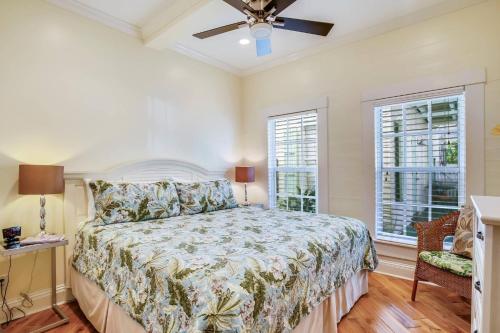 基韦斯特Paradise Place by AvantStay Key West Old Town Condo w Shared Pool的一间卧室设有一张床和两个窗户。