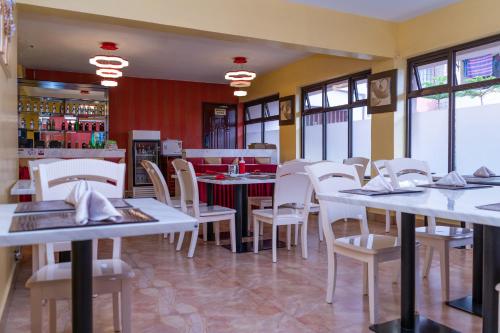 内罗毕肯尼亚轻松酒店的一间设有白色桌子和白色椅子的餐厅
