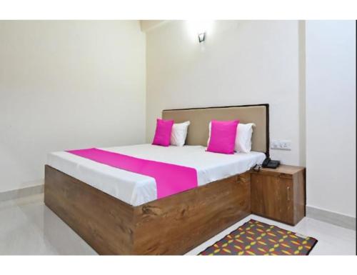 阿格拉Hotel Raj Inn, Agra的卧室配有一张带粉红色枕头的大床