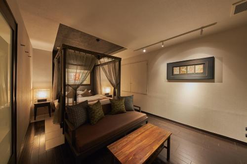 川崎SAKE Kura Hotel 川崎宿的一间配有沙发和一张带窗户的床的客房