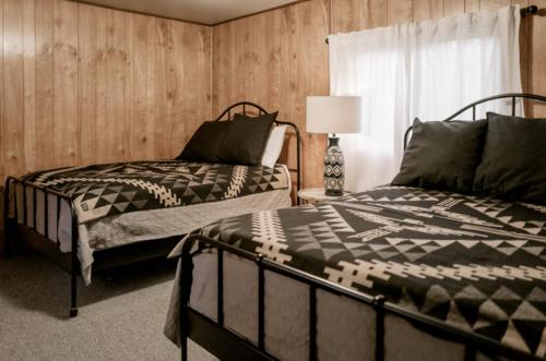 大熊湖2403 - Oak Knoll #4 cabin的一间卧室设有两张床、一盏灯和一扇窗户。
