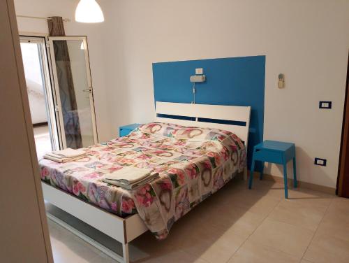 马尔萨拉Calliope的一间卧室配有一张床和一个蓝色床头板