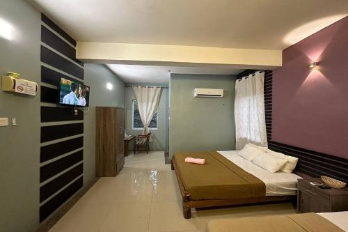 瓜埠Bull & Bear Airport Hotel Langkawi的一间卧室配有一张床和一台平面电视
