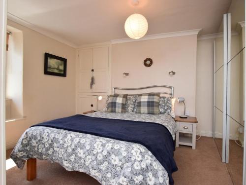布里克瑟姆1 bed in Brixham BX046的一间卧室配有一张带蓝色毯子的床