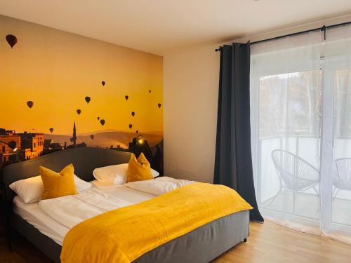 格拉茨APSTAY Serviced Apartments - Self Check-in的一间卧室配有一张带黄色床单的床和一扇窗户。