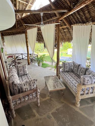 马林迪Cosy Cottage Marine Park at Malindi beach的客厅配有两张沙发和一张桌子