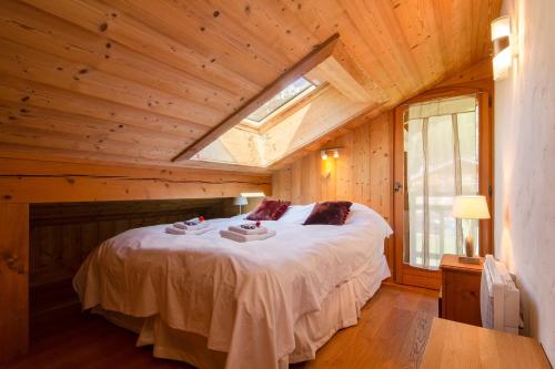 夏蒙尼-勃朗峰Chalets d'en haut - Bonheur - Happy Rentals的木屋内的卧室配有一张大床
