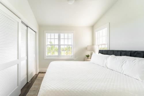 斯托克岛Paradise Point by AvantStay Golf Course Living的一间白色卧室,配有床和2个窗户