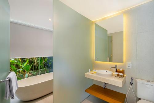 坎古Citadines Berawa Beach Bali的一间带水槽、浴缸和镜子的浴室