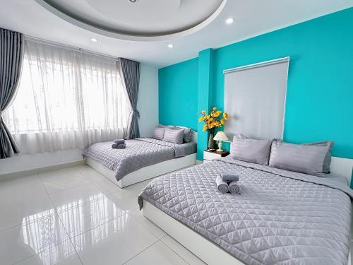 胡志明市Thắng Hà Hotel的蓝色墙壁客房的两张床
