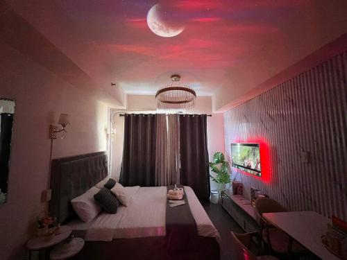 马尼拉Grace Residences Elevate Escapes的一间卧室,配有一张天花板上月亮的床