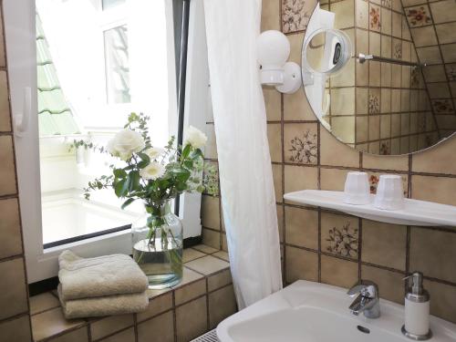 库克斯港吉克海滨酒店的浴室设有水槽、镜子和花瓶