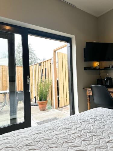 斯内克Bed & Breakfast Waterpoort - incl licht ontbijt的卧室设有滑动玻璃门,可通往庭院。