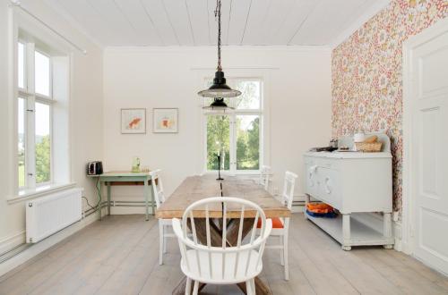 HjältaB&B Bjärtrå的一间带木桌和白色椅子的用餐室