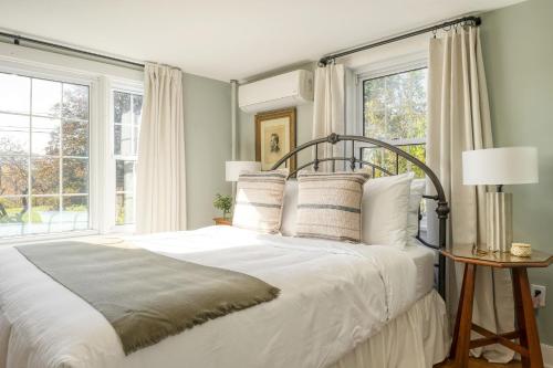 SheffieldWhitney by AvantStay Private Berkshires Estate的一间卧室配有一张带白色床单和窗户的床。