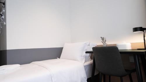 新加坡VicHaus Serviced Apartment的一间卧室配有一张床和一张桌子及椅子