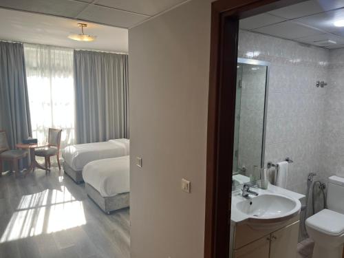 贝鲁特El Sheikh Suites Hotel的浴室设有床、水槽和镜子
