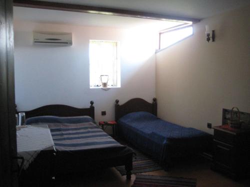 Merdanya贝瓦度假屋的小房间设有两张床和窗户