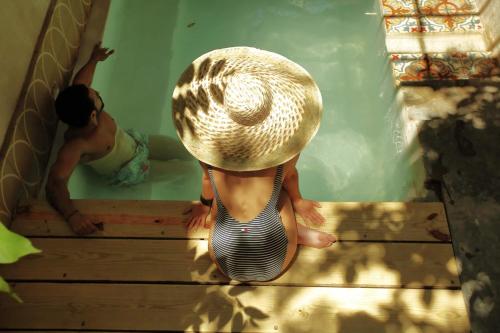圣多明各FIXIE LOFTS Slow Life Villa的两个孩子坐在游泳池的楼梯上