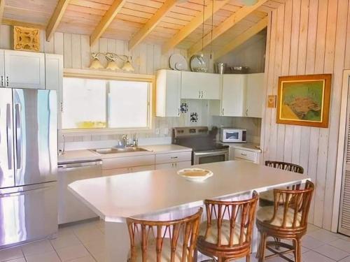 Staniel CaySea Smile的厨房配有桌椅和冰箱。
