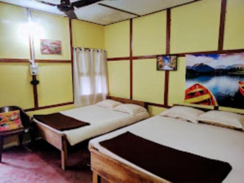帕西加特Nature's Hub Homestay Pasighat的一间卧室配有两张床和一张带台灯的桌子