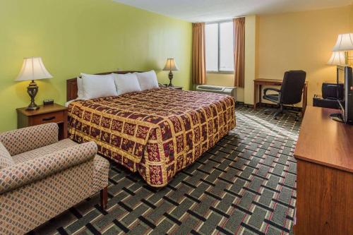 丹维尔丹维尔戴斯酒店&会议中心的配有一张床和一把椅子的酒店客房