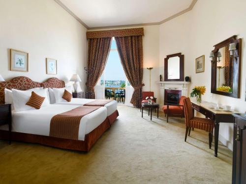 卢克索卢克索索菲特冬宫酒店的酒店客房设有一张大床和一张书桌。