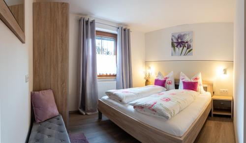 利恩茨Haus Sonnengarten-Lienz的卧室配有带枕头的床铺和窗户。