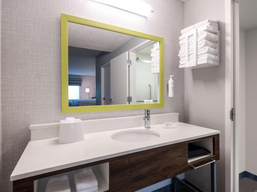 迪尔菲尔德海滩迪尔菲尔德海滩汉普顿酒店的一间带黄色镜子的盥洗盆的浴室