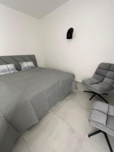 BarcaAtómovy Kryt Košice的一间卧室配有一张床和一把椅子