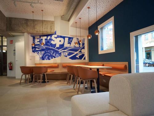 维多利亚-加斯特伊兹Ibis budget Vitoria Gasteiz的一间配备有桌椅的用餐室和蓝色的墙壁