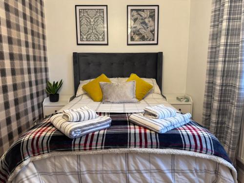 达宁顿堡Brick lodge house的一张带两张毯子和枕头的床