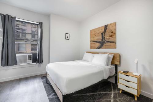 纽约Hotel 27 by LuxUrban的卧室配有白色的床和窗户。