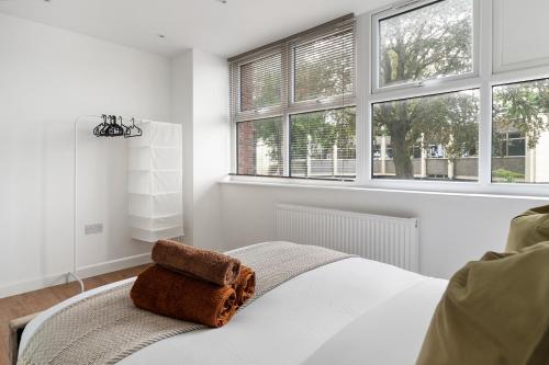 BuckinghamshireLivestay-Modern Apartments Building in Aylesbury的一间白色卧室,配有带2扇窗户的床