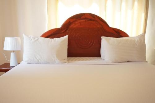 吉汶瓦Asili Nyumbani Residence的一间卧室配有一张大床和两个枕头
