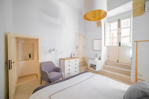 瓦莱塔Carmelita Valletta的一间卧室配有一张床、一把椅子和一个水槽