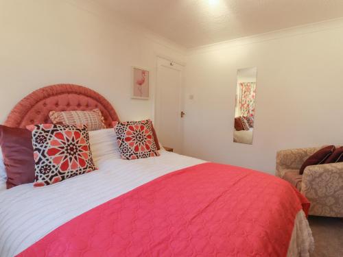 海尔舍姆Lavender Cottage的卧室配有带枕头的大型粉红色床