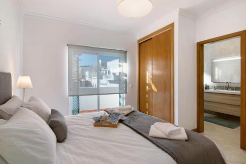 奥良Casa Mar-a-vila的卧室设有一张白色大床和一扇窗户。