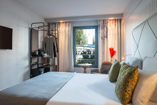 巴黎帕里斯巴黎埃菲尔铁塔酒店的卧室设有一张白色大床和一扇窗户。