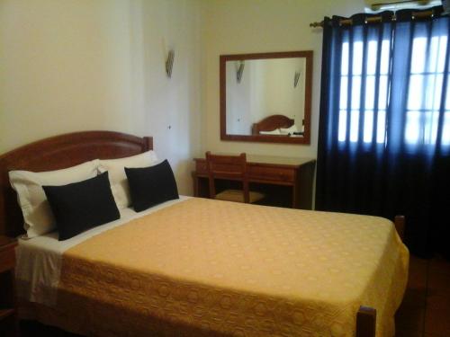 奥德米拉Residencial Idalio的一间卧室配有一张床、镜子和窗户