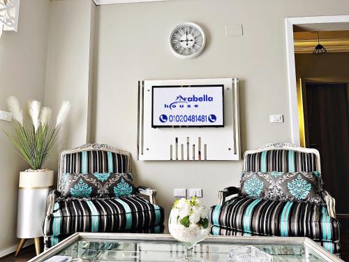 开罗The Arabella House - New Cairo的客厅配有两把椅子和一张桌子