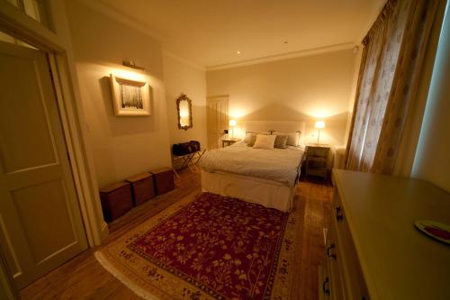 托特兰Old Coastguards - Stunning Historic Cottage的一间卧室配有一张床和红色地毯