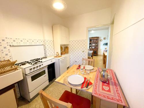 图斯卡尼亚Appartamento nel centro storico di Tuscania - Il Moro的厨房配有桌子和炉灶。 顶部烤箱